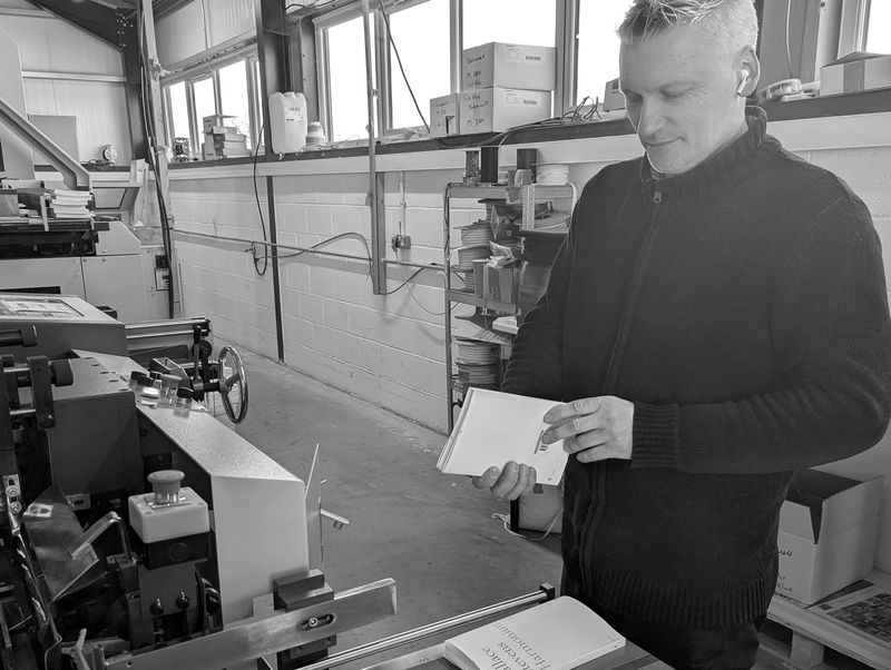 A bound paperback being inspected on the bindery line at our Exeter facility