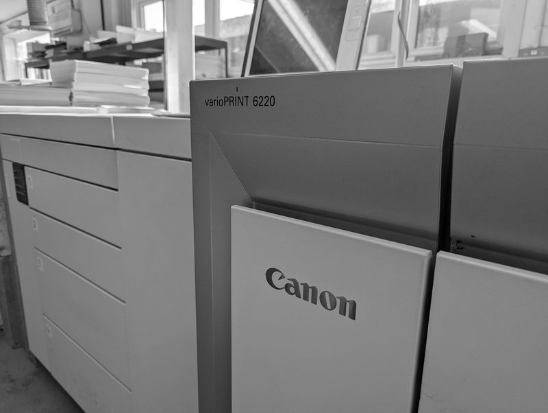 The Canon varioPRINT 6220 mono press, its paper trays and nameplate, black and white
