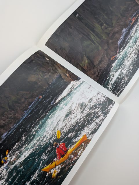 A paperback open flat to a double-page colour photograph running across the gutter