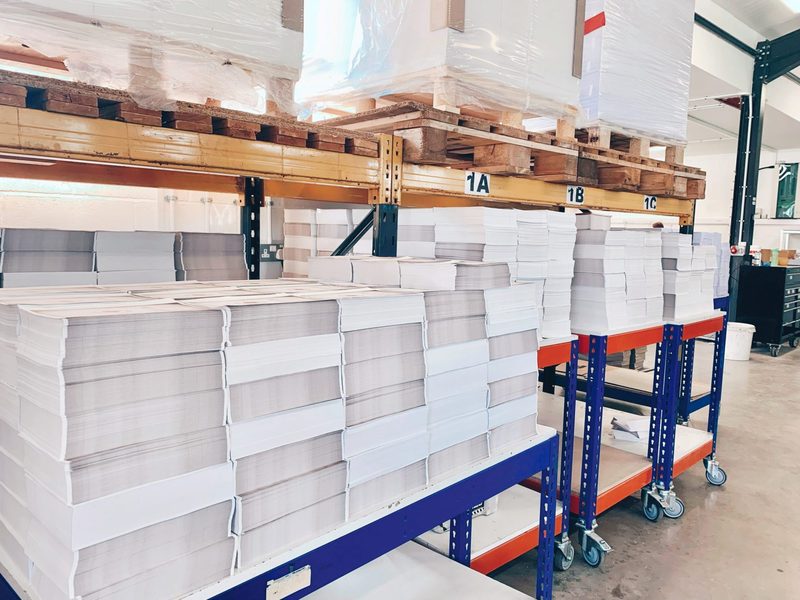 Wrapped text paper stacked on racking and trolleys