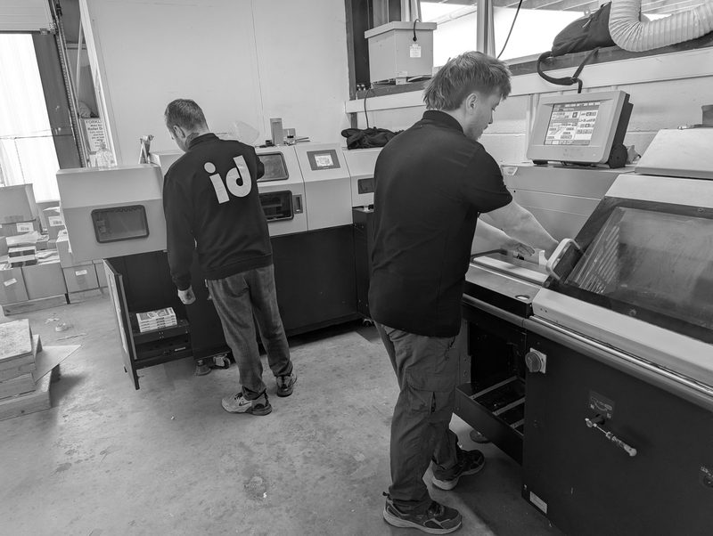 Two operators at the perfect binder in the bindery, black and white
